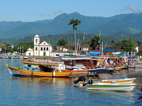 River with lush greenery and boats under a bright sky in Brazil